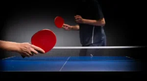 So, you've decided to pick up table tennis, or maybe you're just curious about what makes it such a fast-paced, exhilarating sport. Known for its quick reflexes and finesse, table tennis is both easy to start and challenging to master. Whether you're looking to play recreationally or compete seriously, understanding the basics will set you on the right path. In this guide, we’ll break down everything you need to know on how to play table tennis, from the first serve to advanced strategies.Table tennis isn't just about hitting a small ball back and forth; it’s a game that combines strategy, precision, and agility. And believe it or not, knowing the rules and techniques can make a world of difference. So, let's dive in and get you ready to play like a pro!
What Is Table Tennis?
Before we get into the nitty-gritty of how to play table tennis, let’s get a quick overview. Table tennis, also known as ping pong, is a fast-paced racket sport played on a rectangular table. It involves hitting a lightweight ball back and forth over a small net, with the goal of outscoring your opponent by making the ball bounce twice on their side or forcing them into a missed shot.
Table tennis is played in both singles (one player on each side) and doubles (two players per side) formats, and it’s known for its lightning-speed rallies and highly tactical gameplay. Now that you know the basics, let's talk about how to actually start playing.
#How to Play Table Tennis: Getting Started with the Essentials
1. Understanding the Equipment
To really understand how to play table tennis, it’s essential to get familiar with the equipment you'll be using. The right gear can make a difference, so let’s take a quick look:
Table: A regulation table tennis table measures 9 feet long, 5 feet wide, and 2.5 feet high. It’s divided by a net in the center.
Racket (or Paddle): This is used to strike the ball. Rackets consist of a blade (wooden part) and rubber on both sides. Different rubbers impact spin and speed.
Ball: The standard table tennis ball is 40mm in diameter and weighs about 2.7 grams, usually made of plastic.
Net: The net is 6 inches high and divides the table into two halves.
2. Learning the Rules
Next up in how to play table tennis is learning the basic rules:
Scoring: Games are typically played to 11 points, and a player must win by at least a two-point margin.
Serve: The ball must be thrown vertically at least 6 inches and struck behind the end line. The serve alternates every two points.
Return: After the serve, players take turns hitting the ball back and forth, making sure it bounces once on each side.
Winning: The first player to reach 11 points (with a 2-point lead) wins the game. Matches are usually played in a best-of-five or best-of-seven format.
#How to Play Table Tennis: Mastering Basic Techniques
1. The Basic Stance
Your stance forms the foundation of your game. Stand with your feet shoulder-width apart, knees slightly bent, and lean forward a bit. Your racket should be in your dominant hand, positioned at waist level, and your free hand should balance your body.
2. The Grip
There are two main grips in table tennis: the shakehand grip and the penhold grip.
Shakehand Grip: This is the most common grip, resembling a handshake. It offers versatility for both forehand and backhand strokes.
Penhold Grip: This is more common in Asian countries. It’s held similar to holding a pen, allowing for quick wrist movements but slightly limiting backhand play.
3. The Serve
The serve is a vital component of how to play table tennis. Here are a few key types of serves:
Forehand Serve: Start with the ball in your non-dominant hand, throw it up, and strike it with your racket, aiming for a low trajectory over the net.
Backhand Serve: Similar to the forehand serve, but you strike the ball from a backhand position.
Spin Serve: Adding spin to your serve can make it trickier for your opponent to return. Experiment with topspin, backspin, or sidespin to keep them guessing.
#How to Play Table Tennis: Fundamental Strokes
1. Forehand Drive
This is your go-to attacking shot. Start with your racket back, swing forward as you contact the ball, and follow through. Aim for a quick, flat shot that stays low and forces your opponent to respond quickly.
2. Backhand Drive
The backhand drive is just as important as the forehand. With your racket in front of you, swing your arm horizontally, striking the ball as it comes toward you. Use your wrist to control spin and speed.
3. Push and Chop
Pushes are defensive strokes where you make soft contact with the ball, allowing it to drop close to the net. Chops are similar but involve a downward slice, creating backspin to slow the ball down and throw off your opponent’s rhythm.
#How to Play Table Tennis: Developing Advanced Skills
1. Mastering Spin
Adding spin to your shots can be a game-changer. Spin makes it harder for your opponent to predict the ball's movement and adds an extra layer of complexity to your rallies. The main types of spin are:
Topspin: Brush the ball upward on contact, creating a forward rotation.
Backspin: Slice downwards, causing the ball to rotate backward.
Sidespin: Swipe across the ball sideways to make it curve.
2. The Block
The block is a defensive shot used to return powerful drives. Position your racket to absorb the incoming ball’s speed and return it softly. This move is excellent for turning defense into offense.
3. Smashing
When you see a high, floating ball, it’s time to smash. Swing your racket with maximum power to send the ball toward your opponent’s side with high speed, aiming to end the rally in one shot.
#How to Play Table Tennis: Strategic Tips for Success
Control the Pace: Don’t let your opponent dictate the speed of play. Use a mix of fast and slow shots to keep them on their toes.
Target Weaknesses: Observe your opponent’s weaknesses. If their backhand is shaky, make it your target.
Keep Moving: Footwork is crucial. Try not to remain flat-footed, as quick lateral movements can help you cover the table more effectively.
FAQs About #How to Play Table Tennis
1. What’s the best way to practice table tennis alone?
Using a wall or a table tennis robot is ideal. Practicing serves and strokes repetitively will improve consistency.
2. How do I add spin to my shots?
Brush the ball with your racket at different angles. For topspin, move your racket upwards; for backspin, move it downward.
3. How can I improve my reflexes?
Practice returning serves quickly, and consider using drills designed to boost reaction time.
4. What’s the difference between shakehand and penhold grips?
The shakehand grip offers versatility for both forehand and backhand shots, while the penhold grip allows for more wrist flexibility, especially in forehand strokes.
5. How do I keep track of scoring in table tennis?
Keep tally of points until one player reaches 11 points with a 2-point lead. If the game reaches 10-10, serve changes every point.
Conclusion
Learning how to play table tennis is an exciting journey that can be as simple or as intricate as you want it to be. From mastering basic shots to developing complex spins, table tennis is a sport that offers endless opportunities for improvement. Remember, practice and consistency are key to progressing. So grab your paddle, hit the table, and get ready to level up your game. With patience, strategy, and a lot of practice, you’ll be well on your way to becoming a table tennis pro.